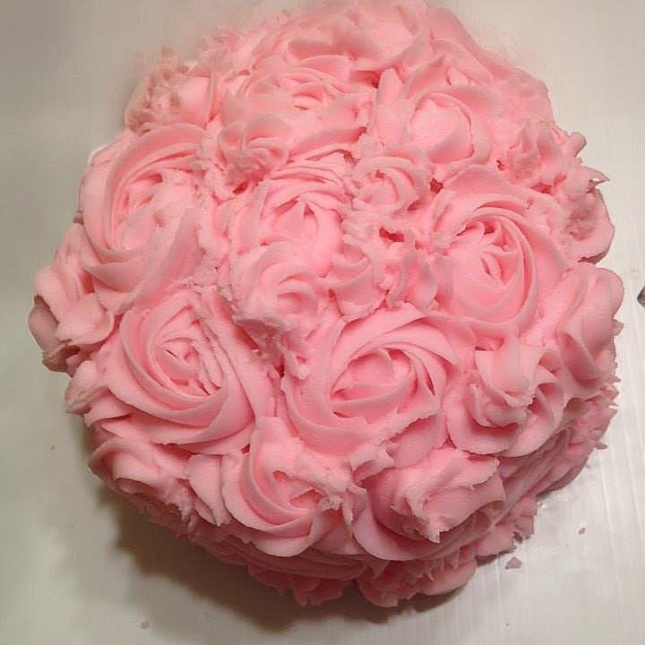 Small round smash cake covered in pink buttercream roses